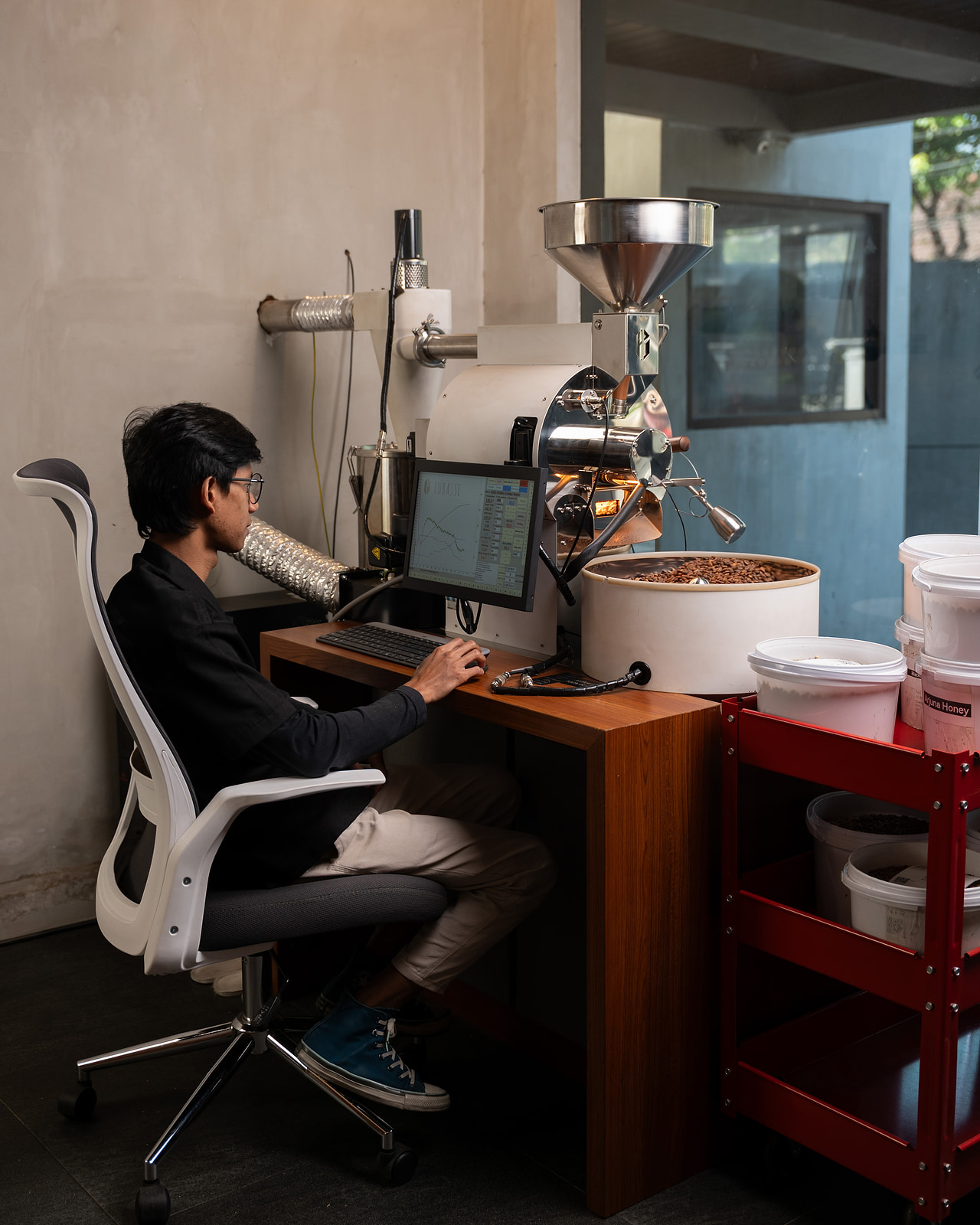 Operator seated at the Rubasse Hyper controller, monitoring the roast curve