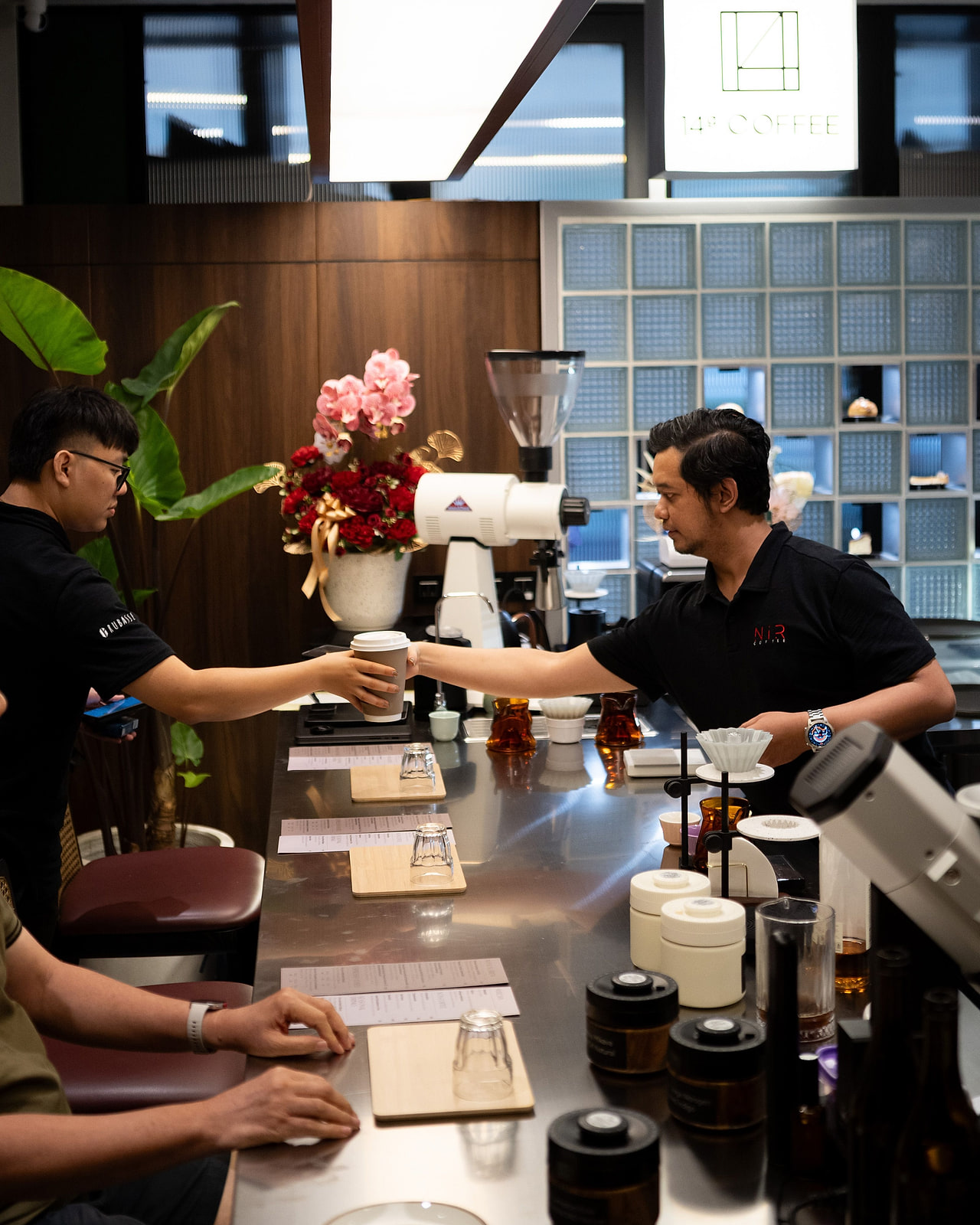 Barista at a cafe bar dialing in the grinder — our beans living in your shop