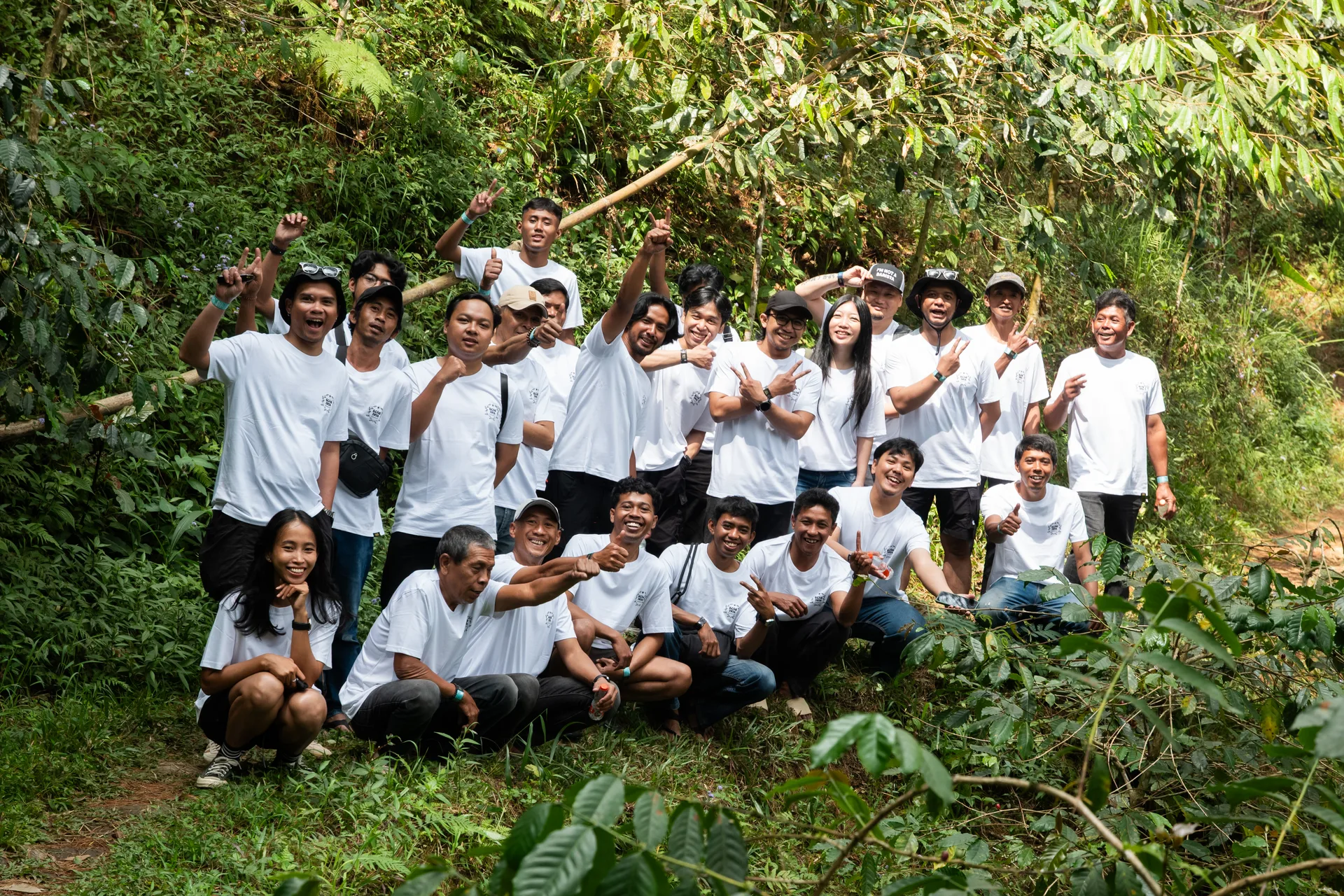 GCAG Indonesia participants and team smiling together among coffee plants.