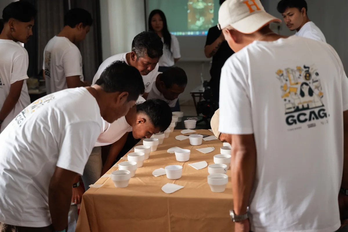 Participants exploring coffee aromas around a cupping table during GCAG Indonesia.